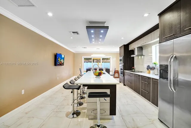 a large kitchen with stainless steel appliances kitchen island granite countertop a table chairs in it and wooden floors