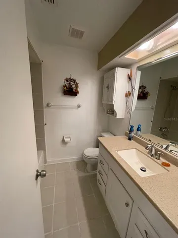a bathroom with a granite countertop sink a toilet and shower