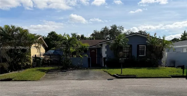 a view of a house with a small yard plants and large tree