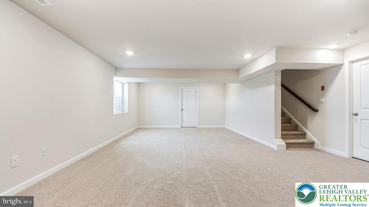 115 Winding Road Easton, PA 18040 - Photo 15 of 24 A spacious, newly carpeted basement awaits your customization, offering ample room for leisure or storage.