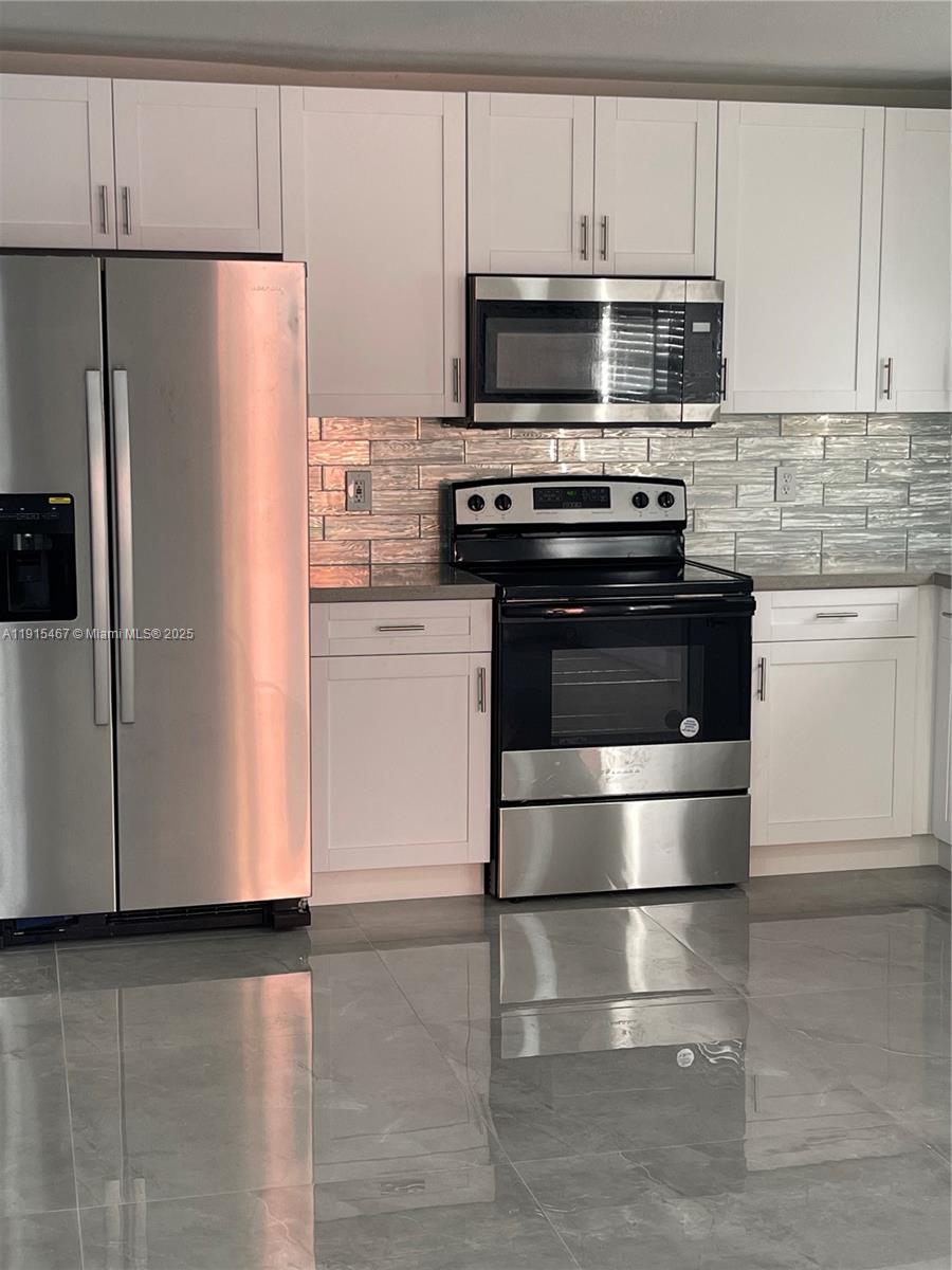 4281 Riverside Drive, Unit 1 Coral Springs, FL 33065 - Photo 3 of 7 a kitchen with appliances and cabinets