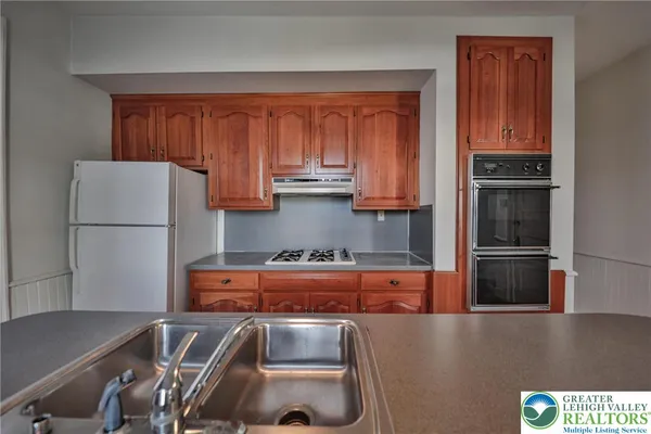 a kitchen with stainless steel appliances granite countertop a refrigerator and a stove top oven