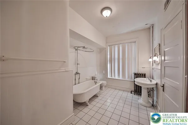 a spacious bathroom with a bathtub a toilet a sink and shower