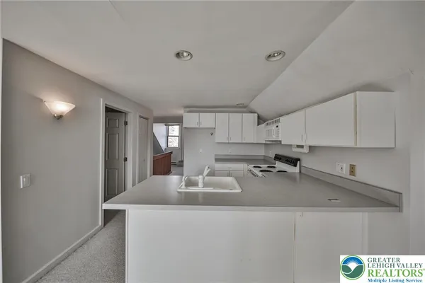 a kitchen with a sink stove top oven and cabinets
