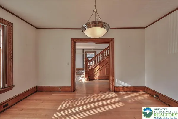 a view of a hallway with wooden floor and a chandelier