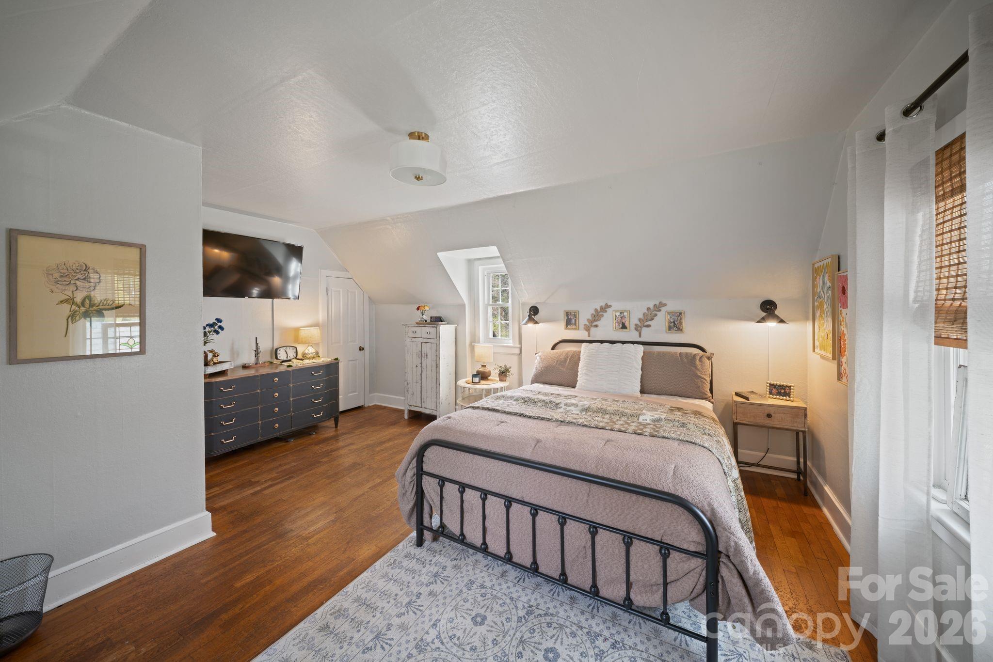 121 Johnson Street Canton, NC 28716 - Photo 28 of 32 a bedroom with a bed a mirror and a flat tv screen on a dresser