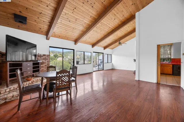 a big room with wooden floor and pool table