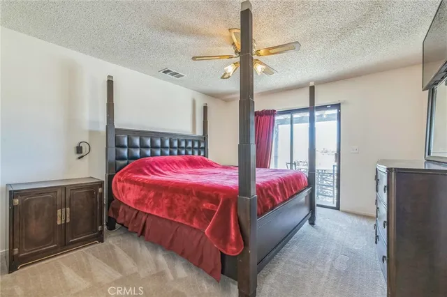 a bed room with a bed and a ceiling fan