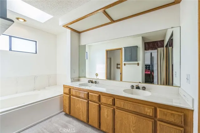 a bathroom with a tub sink and mirror