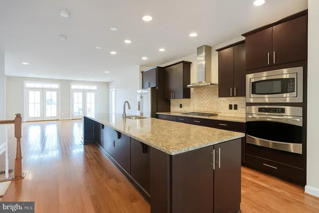 a kitchen with stainless steel appliances granite countertop a stove a sink and a refrigerator