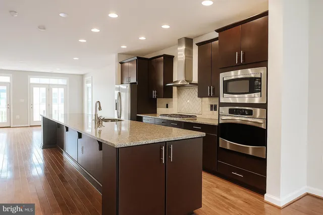 a kitchen with kitchen island granite countertop a stove and a sink