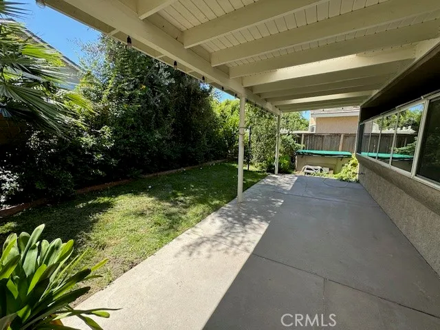 a patio with table and chairs and potted plants