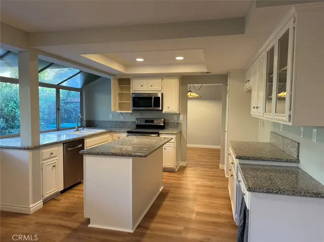 a large kitchen with stainless steel appliances granite countertop a stove a sink and a granite counter tops