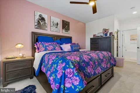 a bedroom with a bed and painting on the wall