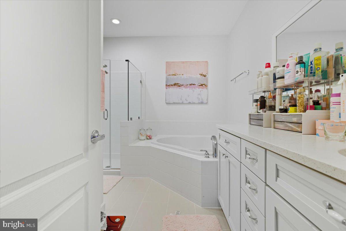 9000 Lorton Station Boulevard, Unit 2115 Lorton, VA 22079 - Photo 22 of 35 a bathroom with a bathtub sink and mirror