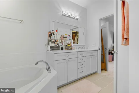 a bathroom with a tub sink and mirror