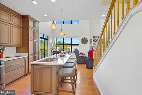 a very nice looking dining room with kitchen island furniture a large window and stainless steel appliances