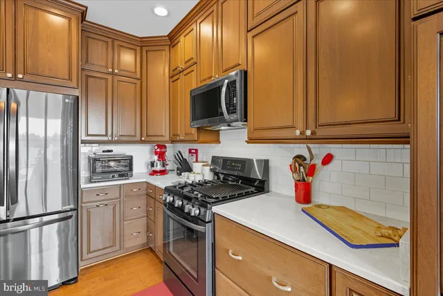a kitchen with stainless steel appliances granite countertop a refrigerator sink and stove