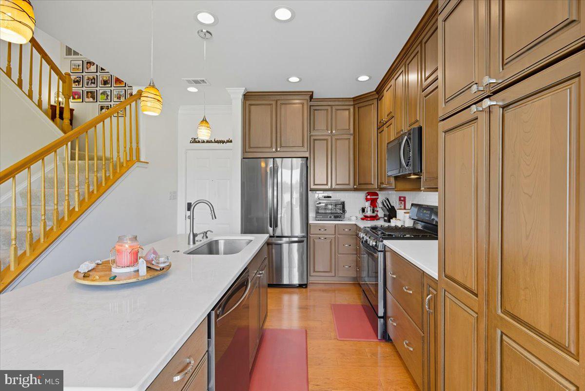 9000 Lorton Station Boulevard, Unit 2115 Lorton, VA 22079 - Photo 7 of 35 a kitchen with stainless steel appliances granite countertop a refrigerator a stove and a sink with wooden floor
