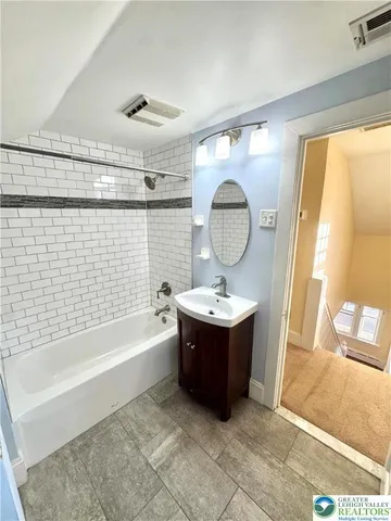 a bathroom with a tub a sink and a mirror