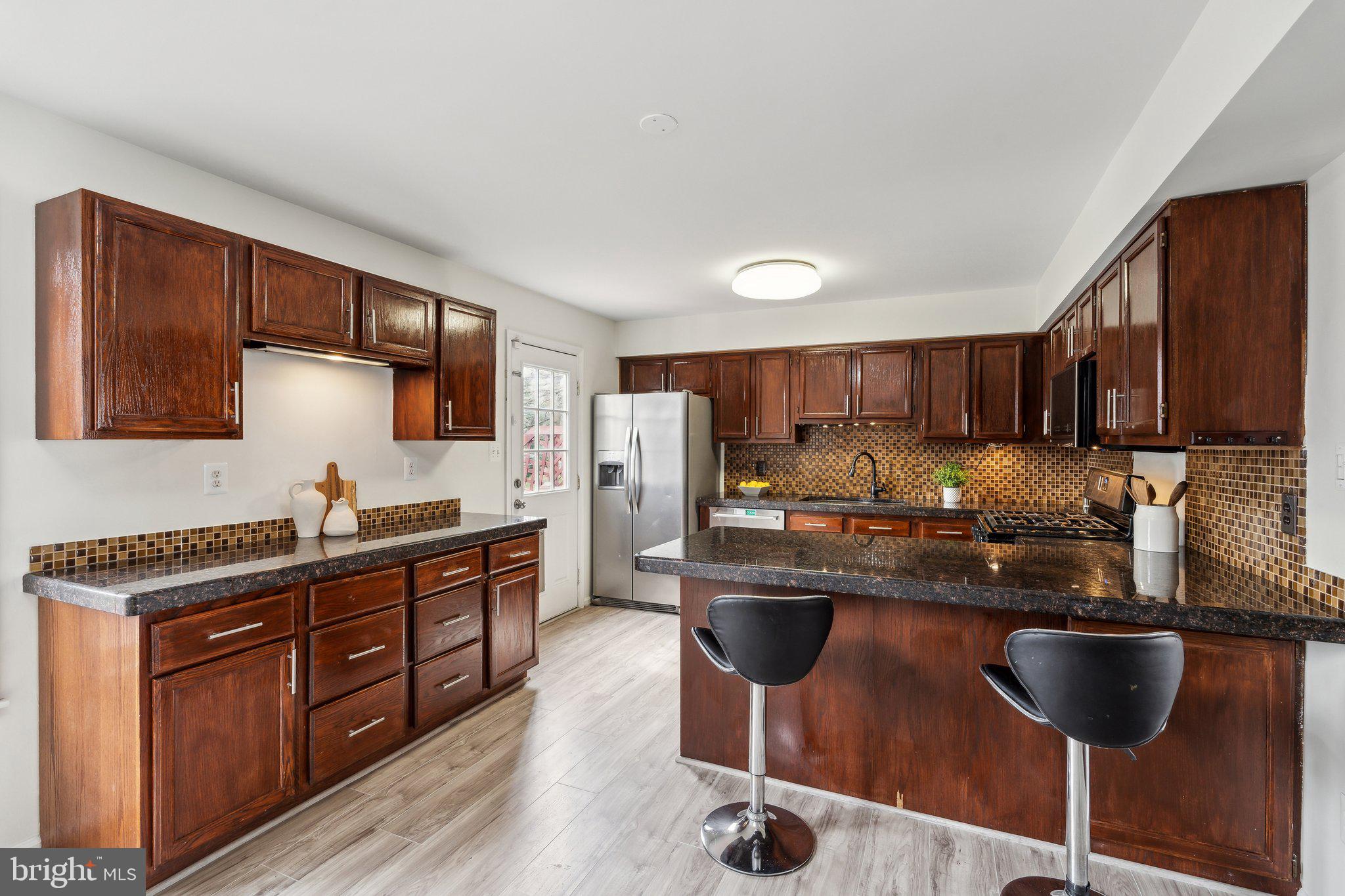 46924 Rabbitrun Terrace Sterling, VA 20164 - Photo 11 of 38 a kitchen with stainless steel appliances granite countertop a sink stove and refrigerator