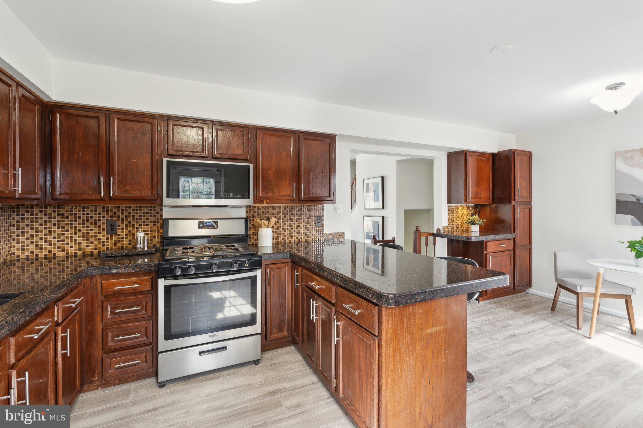 46924 Rabbitrun Terrace Sterling, VA 20164 - Photo 15 of 38 a kitchen with stainless steel appliances granite countertop a stove a sink dishwasher a microwave oven and a refrigerator