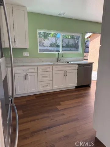 a view of kitchen with granite countertop cabinets and wooden floor