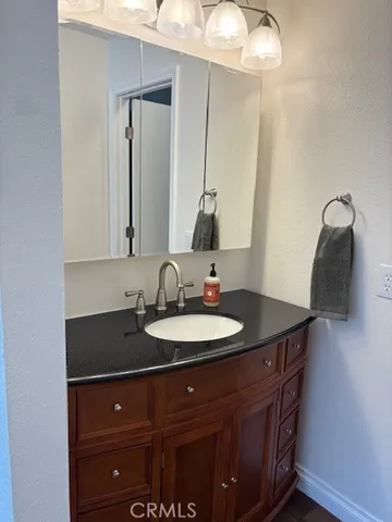 a bathroom with a granite countertop sink and a mirror