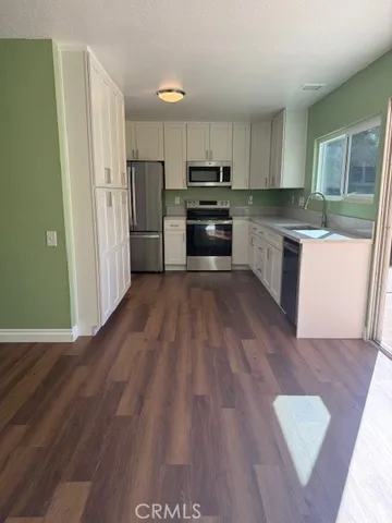 a kitchen with wooden floors and white appliances