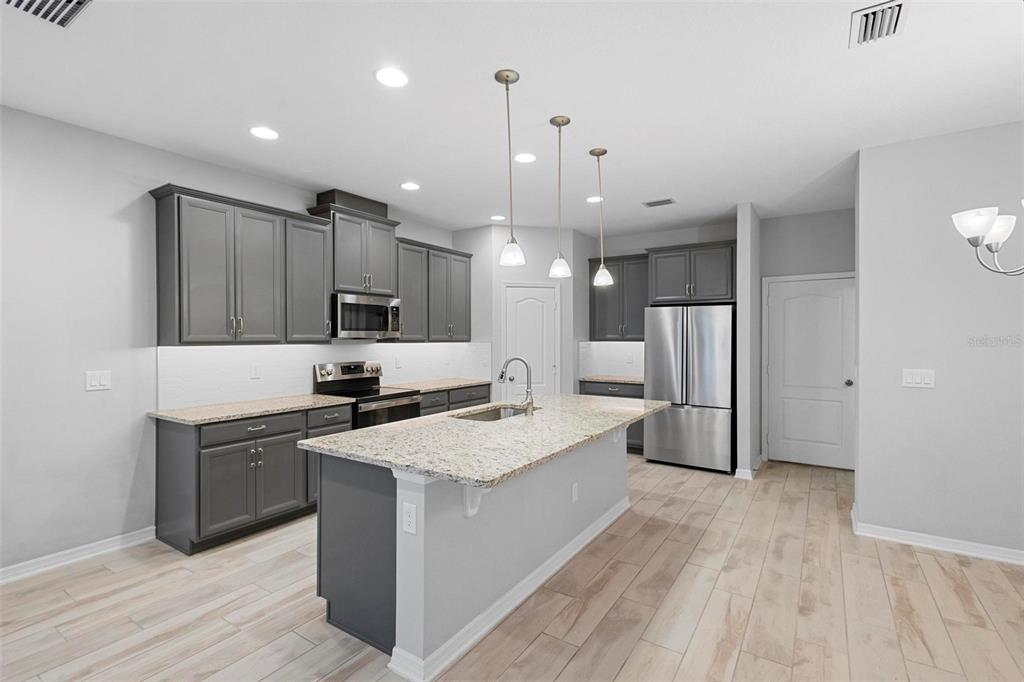 730 Rivington Drive DeBary, FL 32713 - Photo 22 of 47 a kitchen with a refrigerator a sink and wooden floor