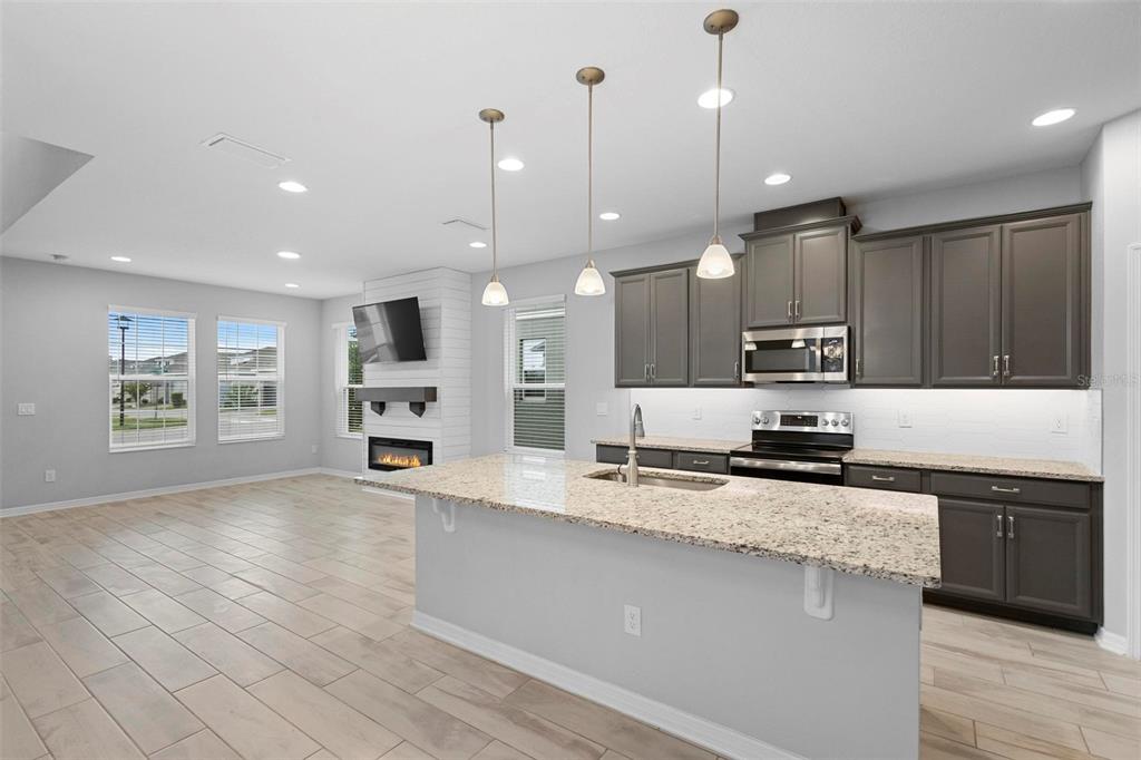 730 Rivington Drive DeBary, FL 32713 - Photo 23 of 47 a large kitchen with stainless steel appliances kitchen island granite countertop a stove a sink and a granite counter top