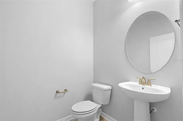 a bathroom with a sink a toilet and mirror