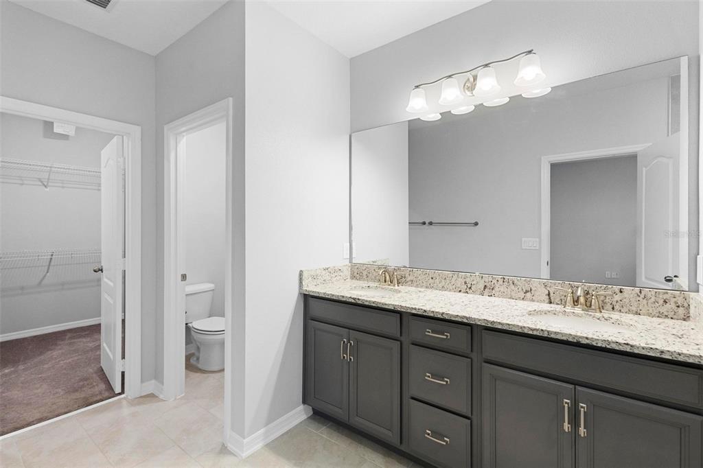 730 Rivington Drive DeBary, FL 32713 - Photo 38 of 47 a bathroom with a granite countertop sink a toilet and a mirror