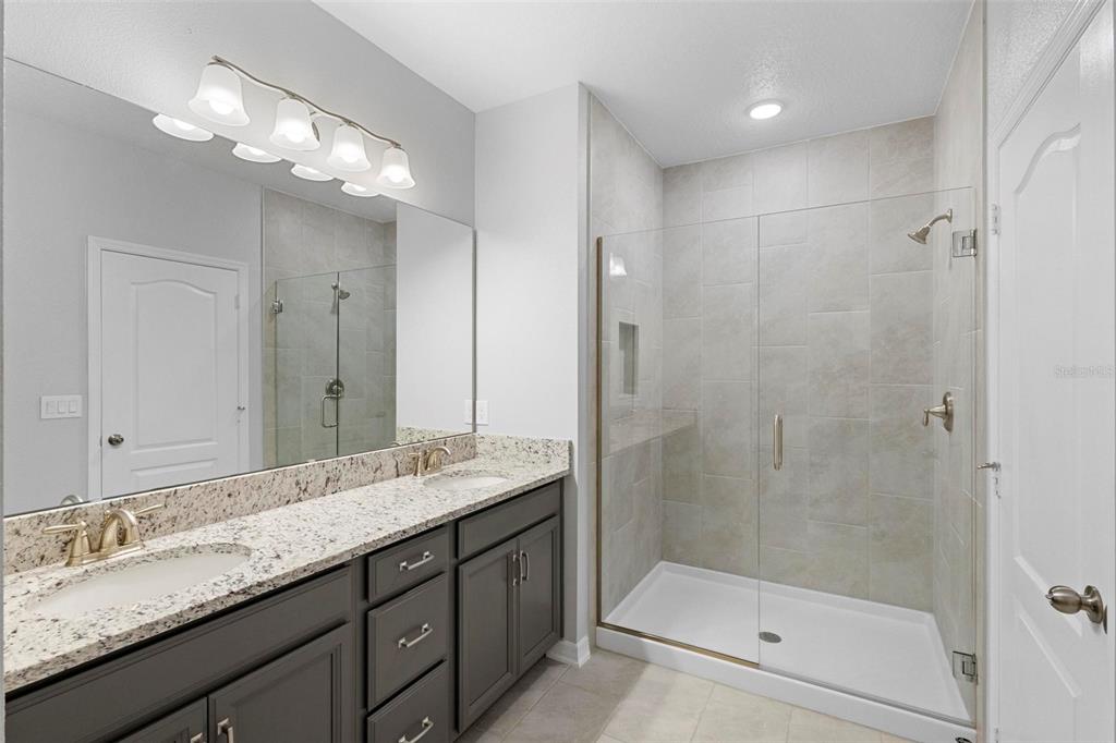 730 Rivington Drive DeBary, FL 32713 - Photo 39 of 47 a bathroom with a granite countertop sink a large mirror and shower