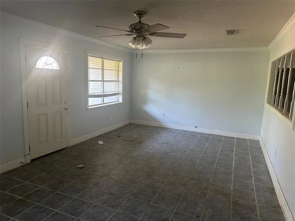an empty room with windows and fan