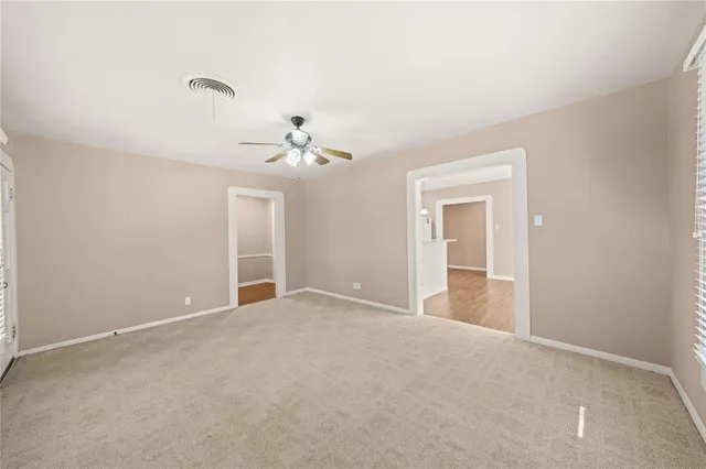 a view of an empty room with a chandelier fan