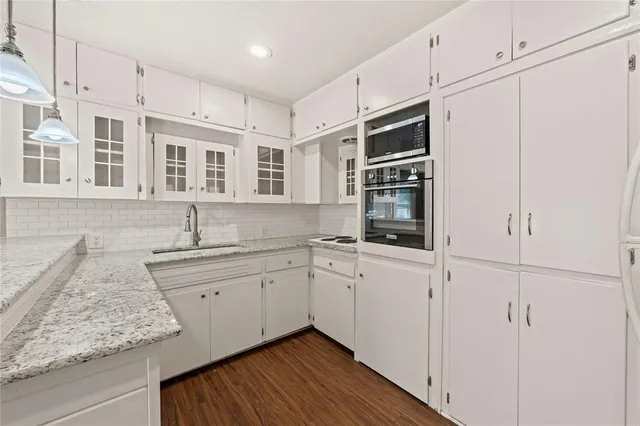 a kitchen with stainless steel appliances granite countertop a sink and dishwasher next to a large window