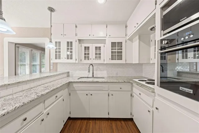 a kitchen with stainless steel appliances granite countertop a sink and dishwasher with white cabinets