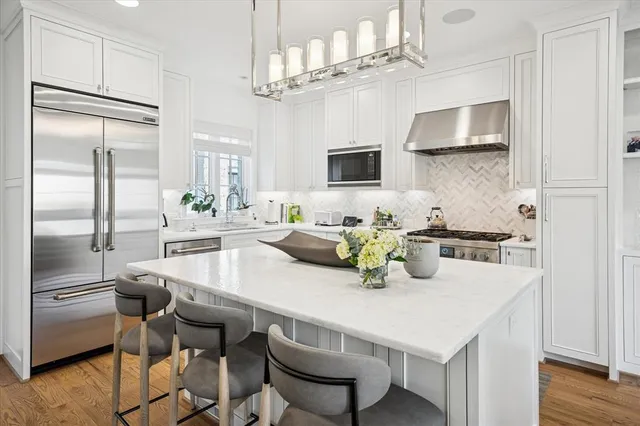 a kitchen with kitchen island a table and chairs in it