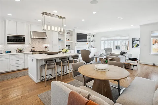 a living room with furniture a flat screen tv and kitchen view