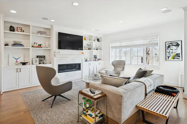 a living room with furniture a flat screen tv and a fireplace