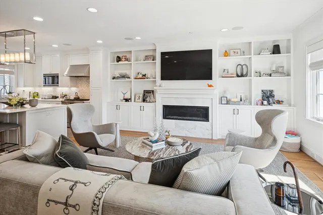 a living room with furniture kitchen view and a flat screen tv