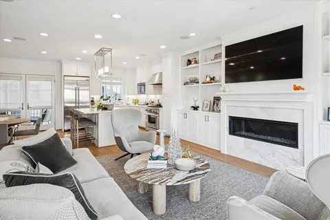 a living room with furniture a flat screen tv and kitchen view