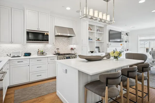 a kitchen with stainless steel appliances a table chairs microwave and cabinets