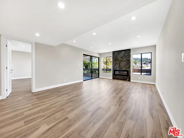 an empty room with wooden floor and a window