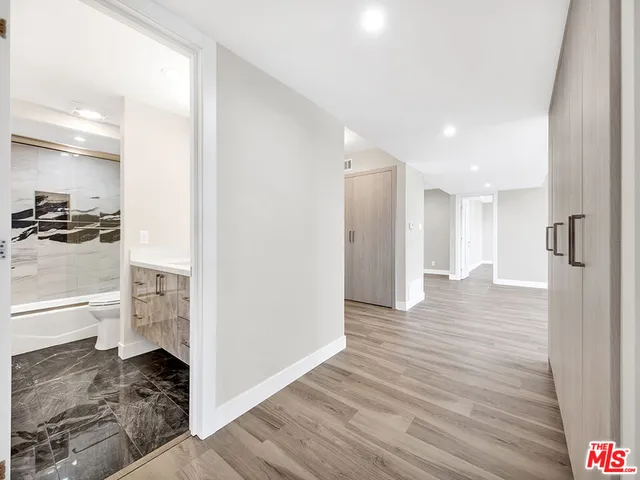 a view of a hallway to closet and wooden floor