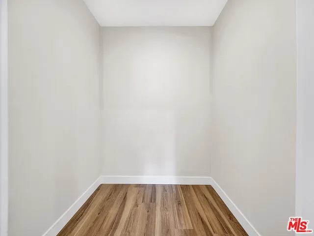 a view of a small space with wooden floor and a window
