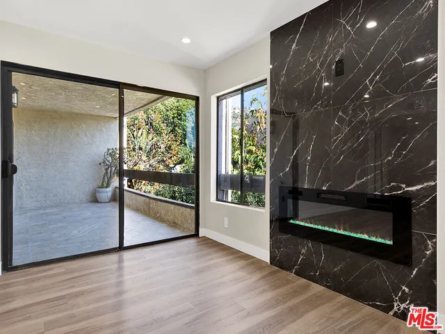a view of a room with wooden floor and a floor to ceiling window