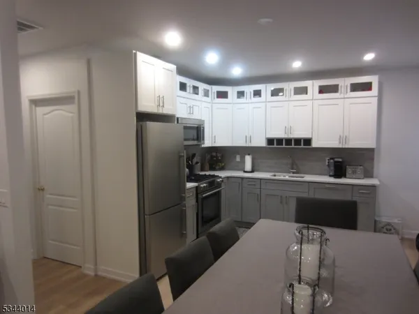 a kitchen with a refrigerator and a stove top oven