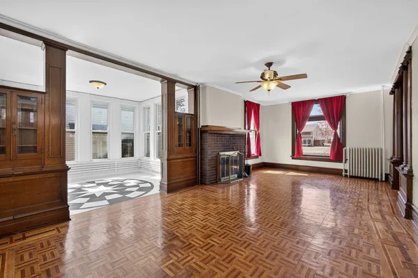 a view of a livingroom with wooden floor a fireplace and window
